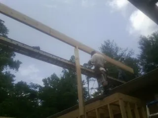 Carpenter setting a ridge beam over a new addition frame — Ice Dam Removal by Roofing Brothers in Nacogdoches