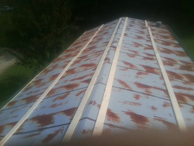 Rusted metal roof panels with new wood purlins before replacement — Storm Damage Roof Repair in Nacogdoches by Roofing Brothers