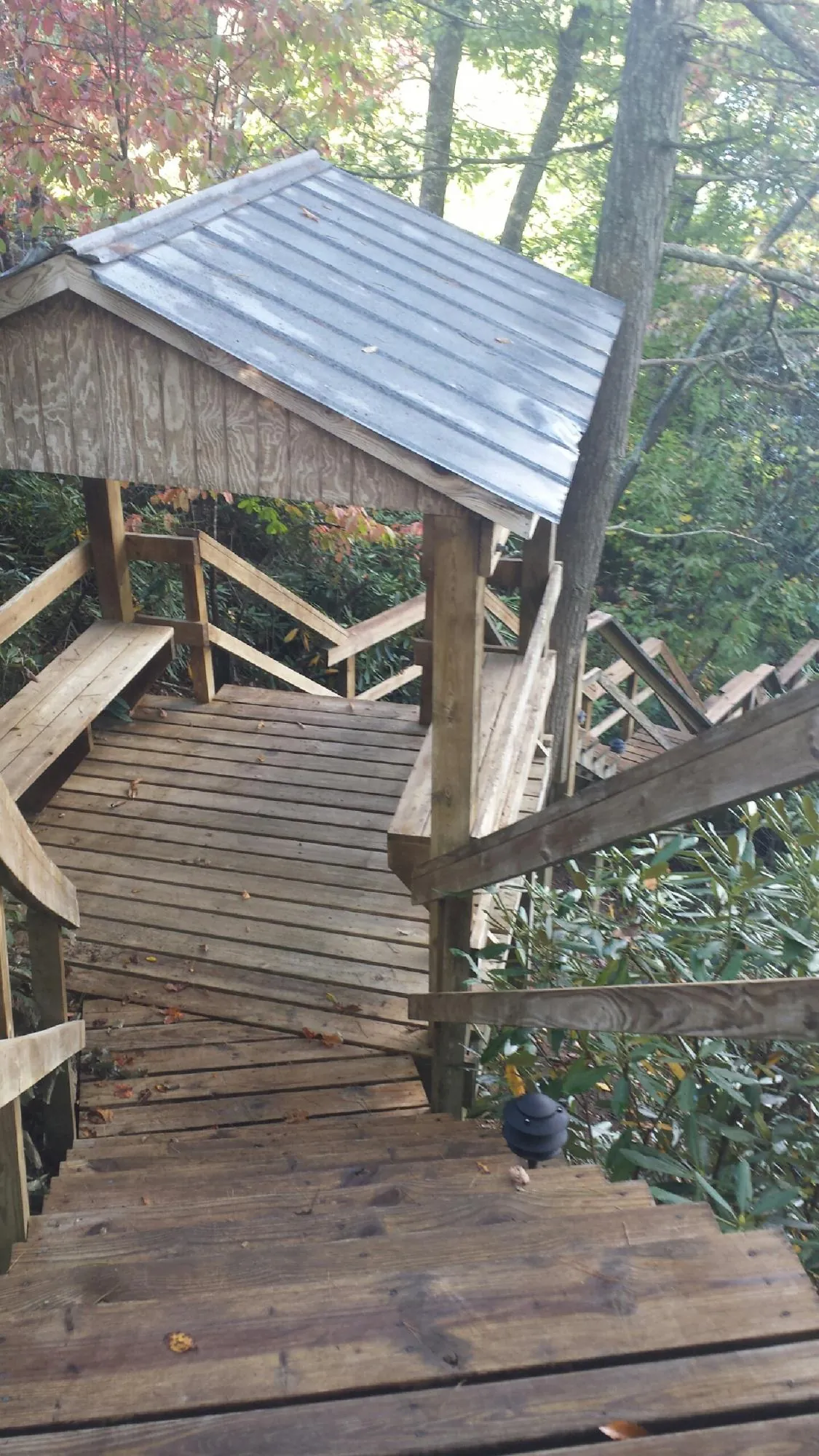 Metal roofed shelter over wooden steps on a wooded walkway — Skylight Repair & Installation work by our crew in Nacogdoches