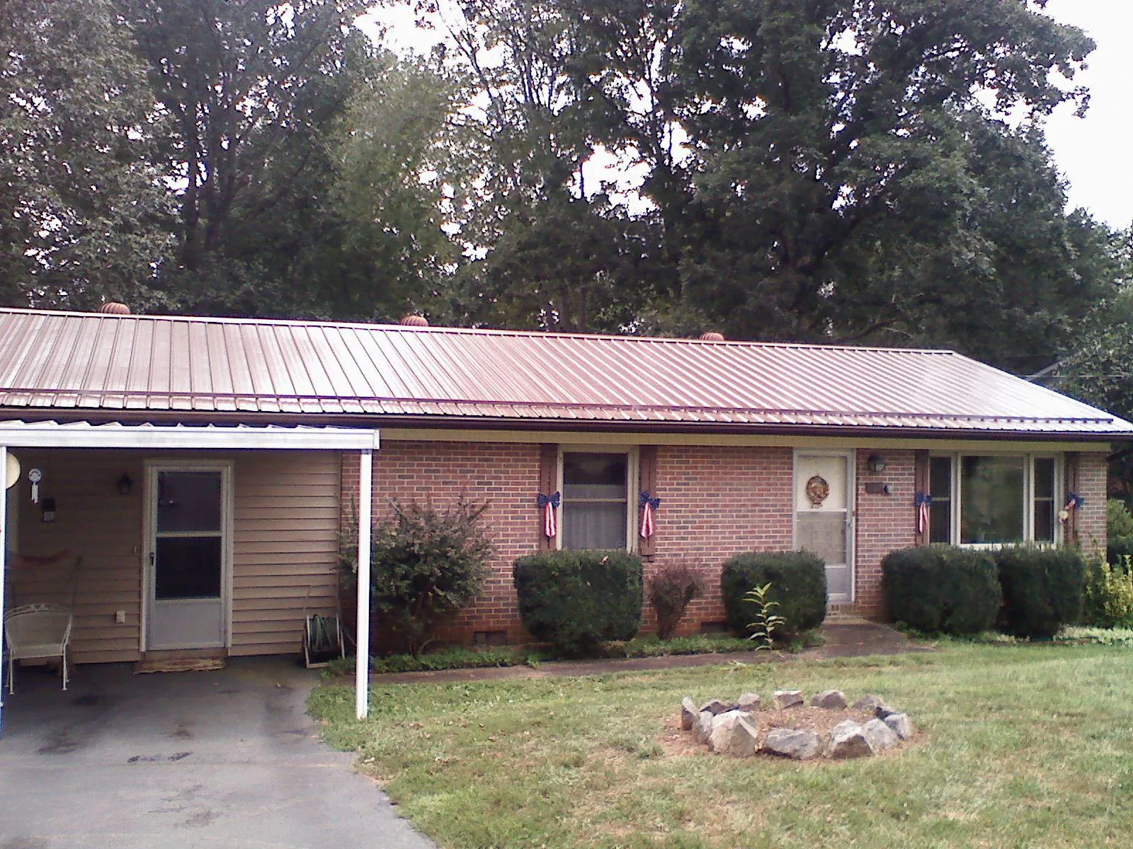 Bronze metal roof and carport on a brick ranch home — Roof Repair work by our crew in Nacogdoches